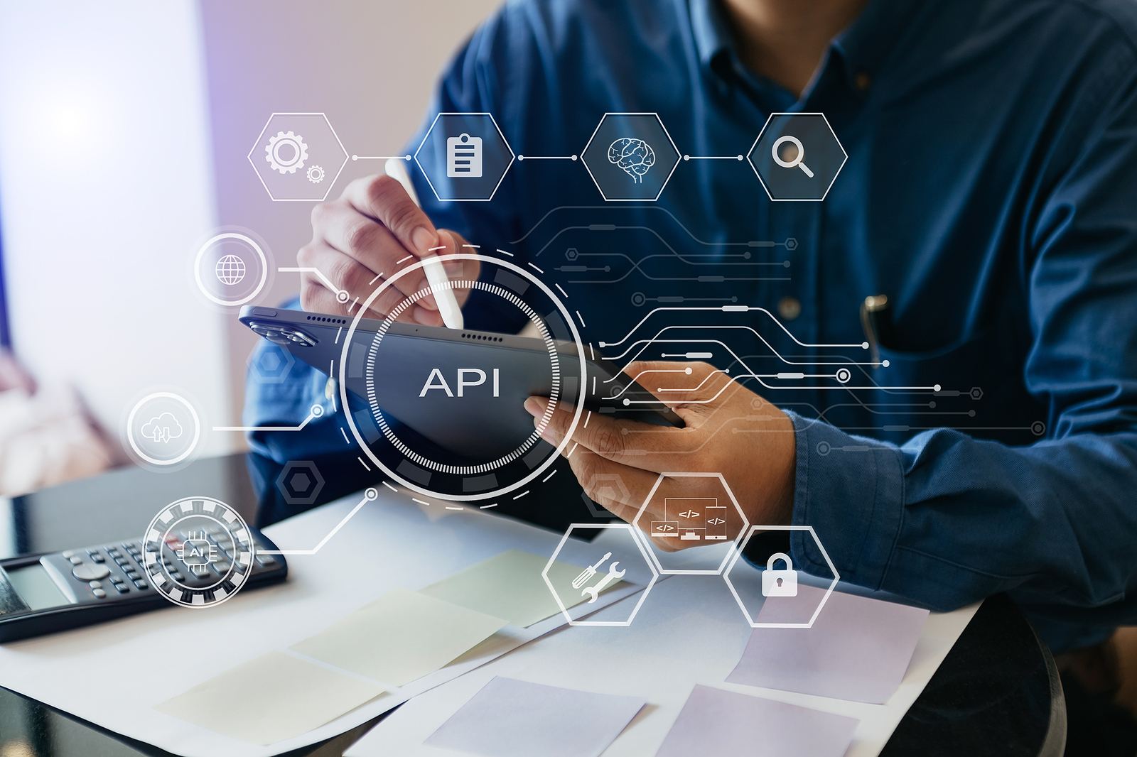 A person using a tablet with an API and database connection graphic overlaid